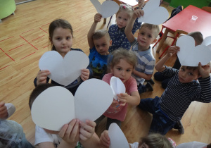 Dzieci pokazują wycięte z papieru serca